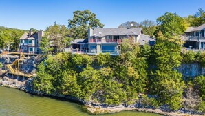Une propriété située sur la côte, comprenant plusieurs maisons, un quai et une plage rocheuse.