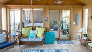Un intérieur en bois avec un canapé, des fauteuils et un motif de poisson décorant le plafond.