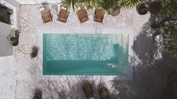 Een buitenzwembad, parasols bij het zwembad en ligstoelen