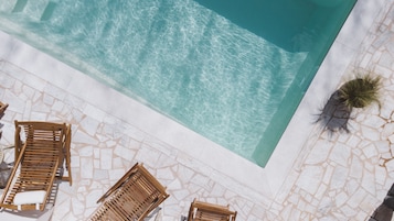 Een buitenzwembad, parasols voor strand/zwembad