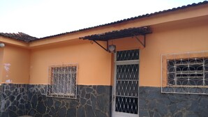 A building with a stone and plaster exterior, a tiled entrance, and barred windows. - Pousada do joao (Juiz de Fora)