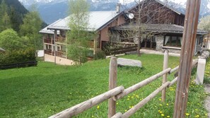 Set amidst a serene landscape, this charming chalet offers a peaceful retreat with a stone chimney and balcony.