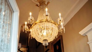 A grand staircase with ornate woodwork and a chandelier. - Anchuca Historic Mansion & Inn (Vicksburg)