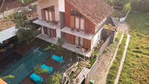 A two-story house with a swimming pool, outdoor seating, and a garden. - Kubu Tropis (Ubud)