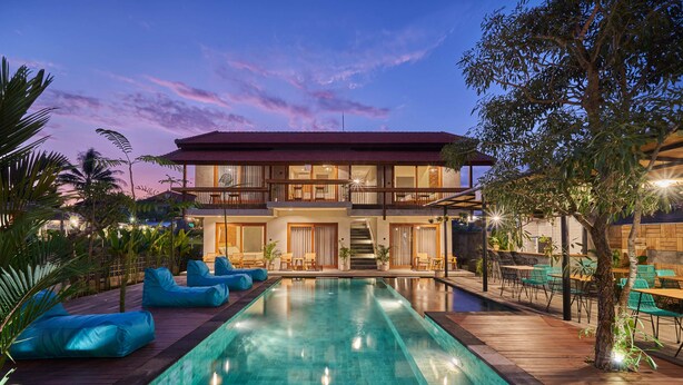 A two-story house with a swimming pool, outdoor seating, and a balcony. - Kubu Tropis (Ubud)