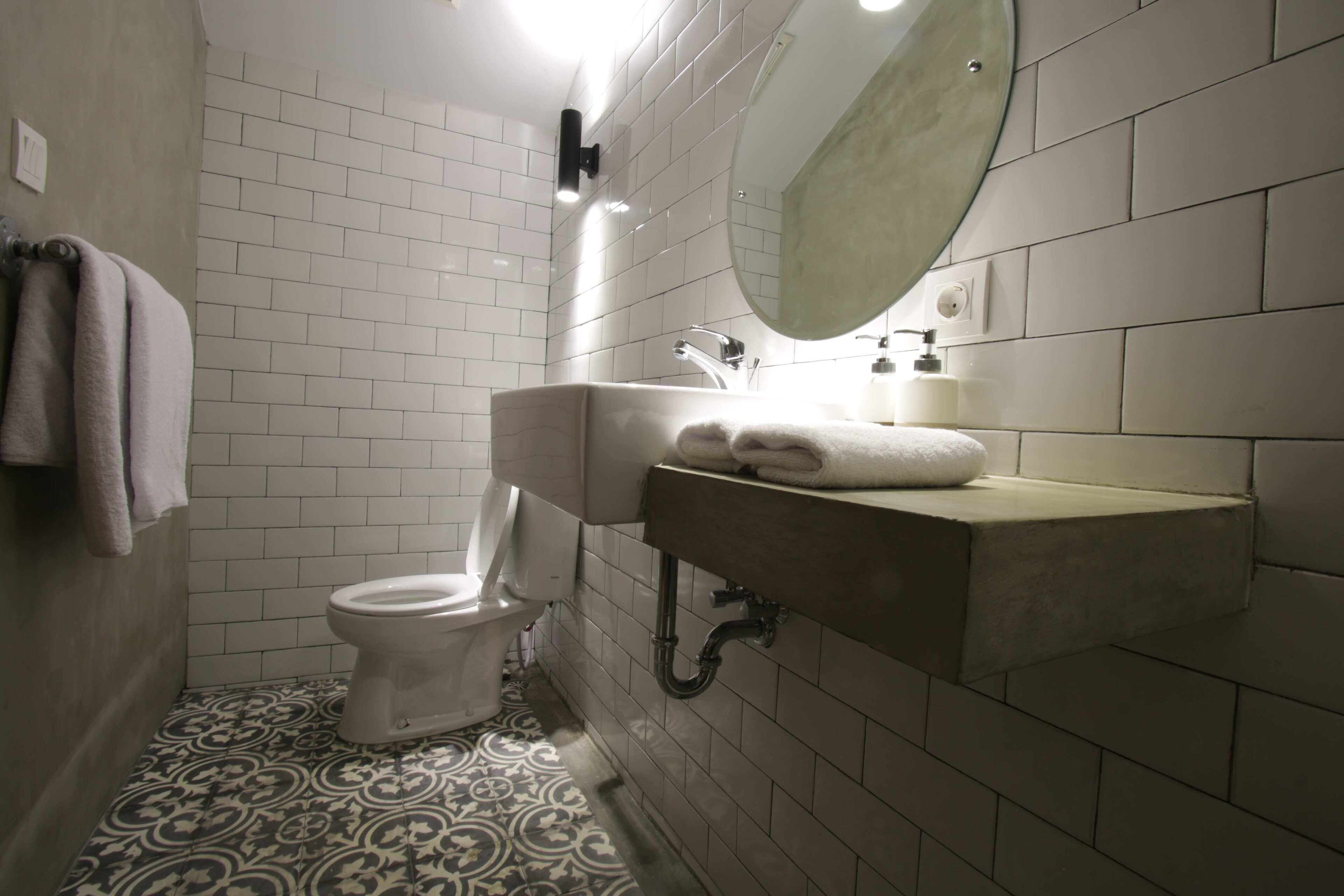 A bathroom with a toilet, sink, and mirror.