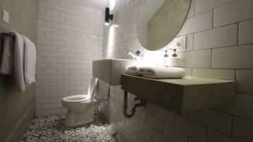 A bathroom with a toilet, sink, and mirror.