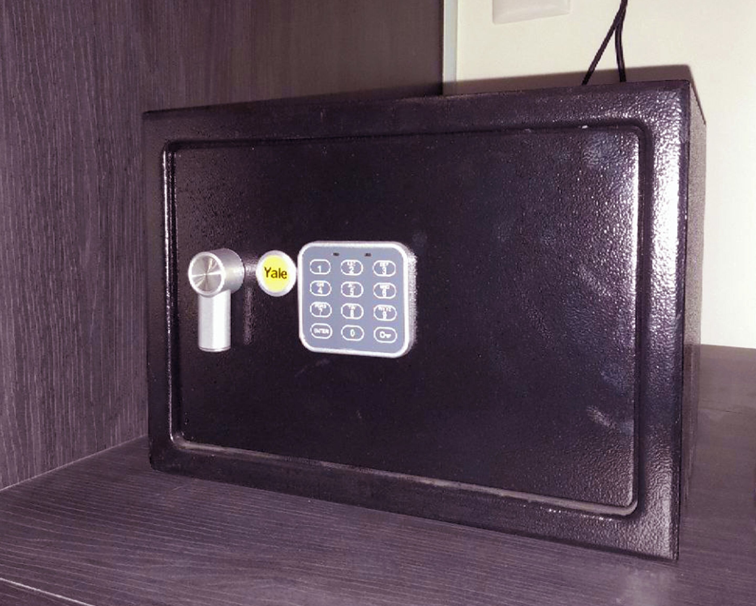 Um cofre preto com fechadura Yale e teclado numérico.