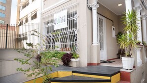 A building with a sign reading "QUNSAI HUSTELBAR". - Quintal Hostel (São Paulo)