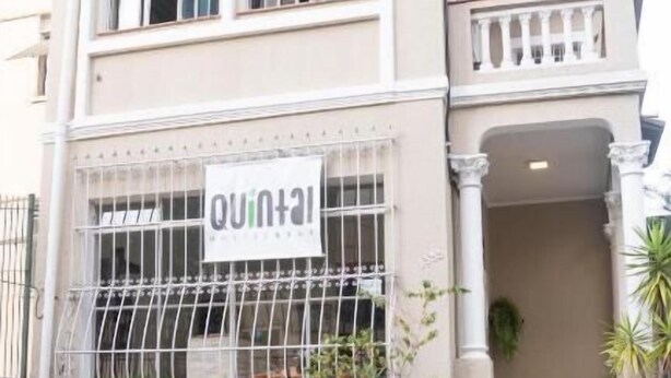 A two-story building with a sign reading "QUINTAL". - Quintal Hostel (São Paulo)