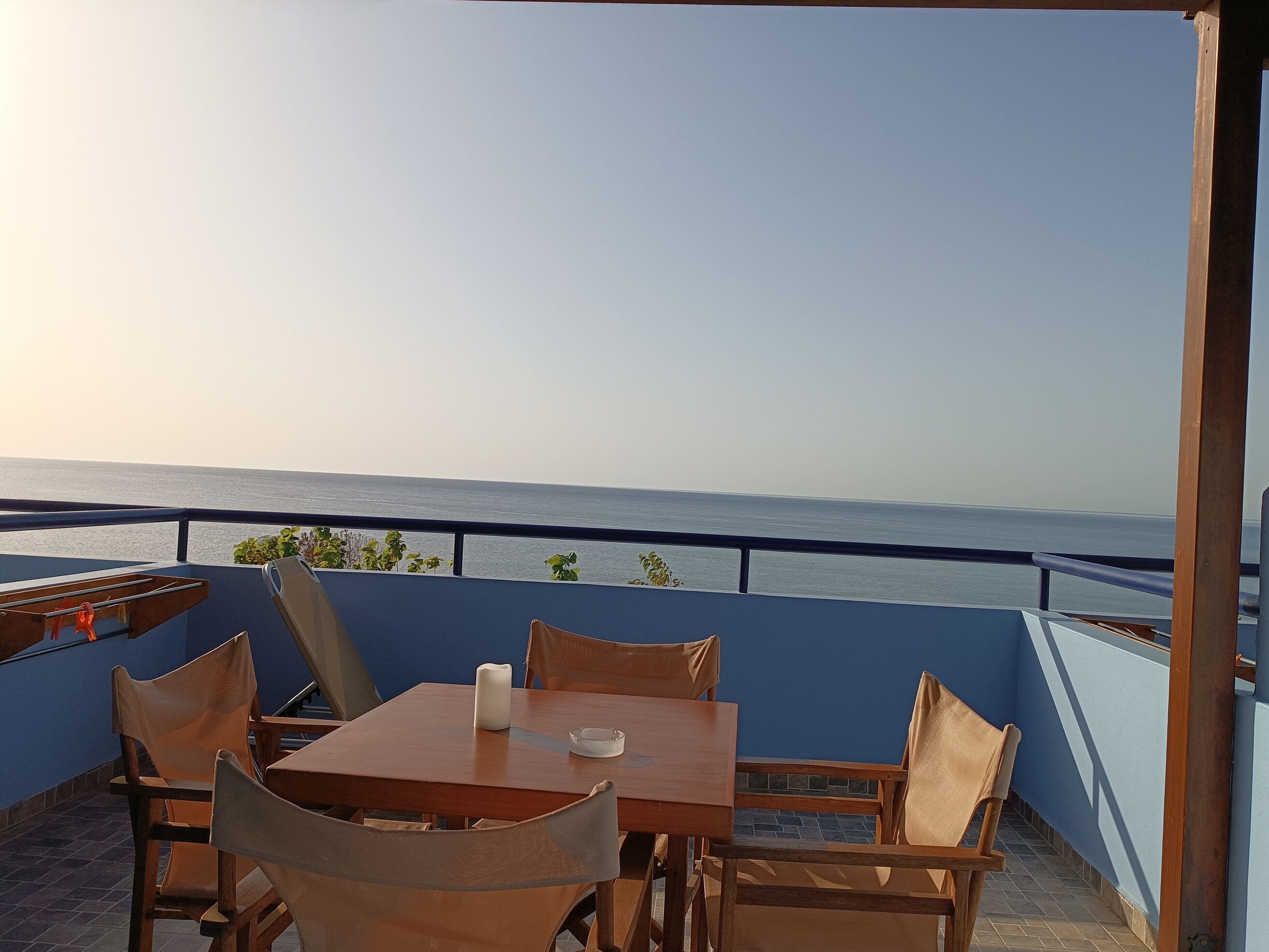 Una terraza con mesa y sillas, con vista a un cuerpo de agua.
