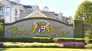 A sign for the World Tour Golf Links with a crest and the name in gold lettering. - Pretty Peony Steps to Pool - Myrtle Beach, SC (Myrtle Beach)