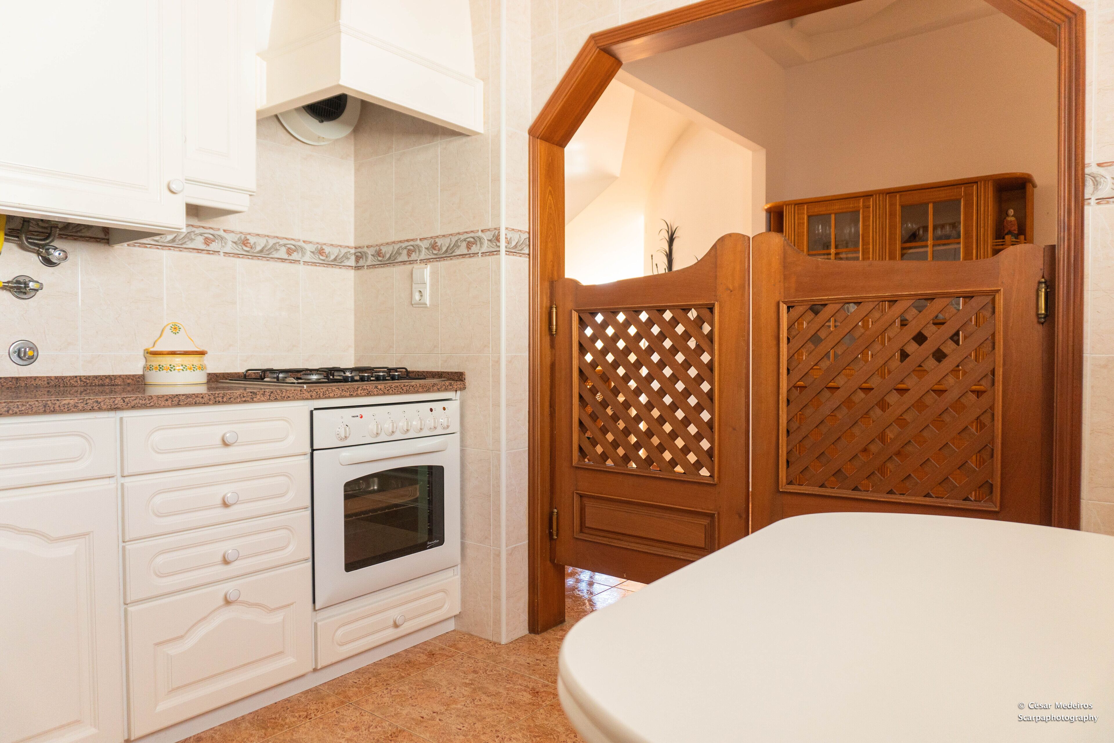 A kitchen with white cabinets, a stove, and an oven.
