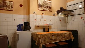 A small kitchen with a coffee maker, a kettle, and a table with a tablecloth. There are fish decorations on the wall and a framed picture above the sink. - AMZEI Studio historic center, terrace, very quiet, downtown (Bucharest)