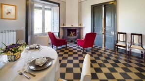 A dining area with a checkered floor, two red chairs, a table set for two, and a fireplace. - Villa for 10 People with private pool, garden and free WiFi (Randazzo)