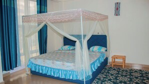 Un dormitorio con una cama, una mesita de noche, una ventana con cortinas y una decoración en la pared.