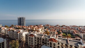 A coastal residential area with a mix of modern and traditional architecture, including a prominent high-rise building and numerous houses with red-tiled roofs. - Apartments Arcadia. Panorama of the sea. 3 bedrooms  (Odessa)