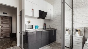 A modern kitchen with a black countertop, white cabinets, and a built-in oven. - Apartments Arcadia. Panorama of the sea. 3 bedrooms  (Odessa)