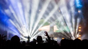 Un concert amb llums d'escenari i una multitud de persones.