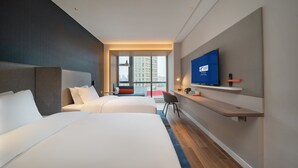 A modern hotel room with two beds, a TV, a desk, and a view of a cityscape. - Holiday Inn Express Huaibei City Center by IHG (Huaibei)
