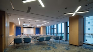 A conference room with tables, chairs, and a large screen. - Holiday Inn Express Huaibei City Center by IHG (Huaibei)