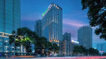 A high-rise hotel with multiple floors, large windows, and a prominent sign at the top.