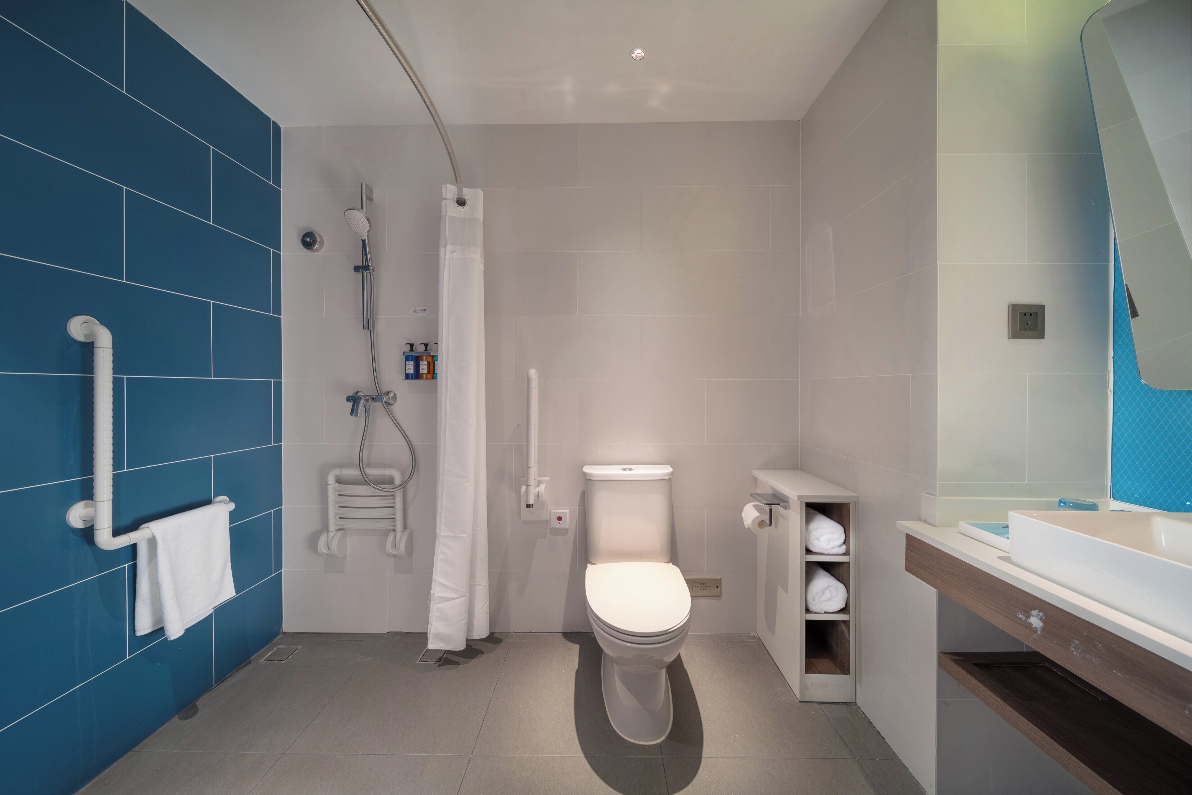 A modern bathroom with a shower, toilet, and sink.