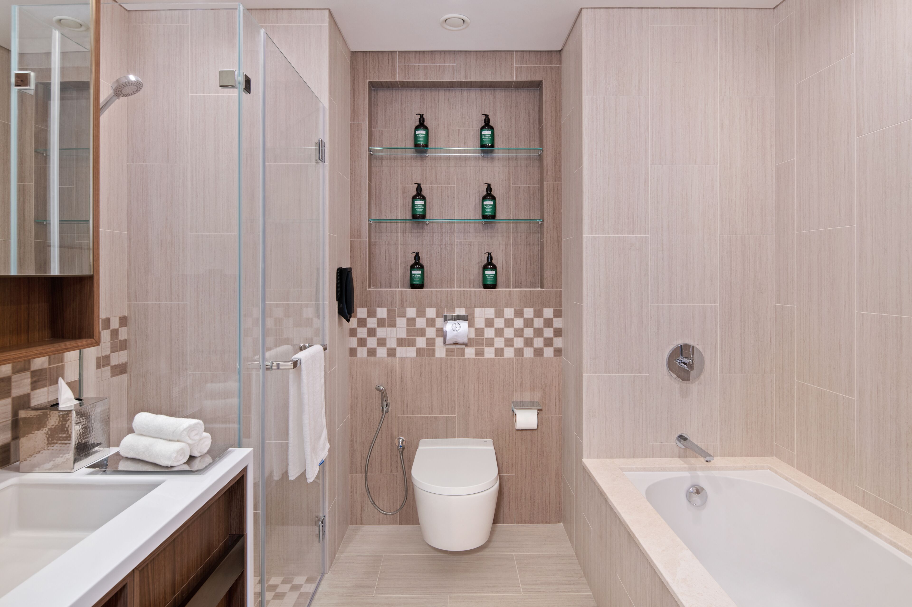 A modern bathroom with a glass shower enclosure, a toilet, a bathtub, and shelves with toiletries.