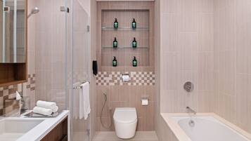 A modern bathroom with a glass shower enclosure, a toilet, a bathtub, and shelves with toiletries.