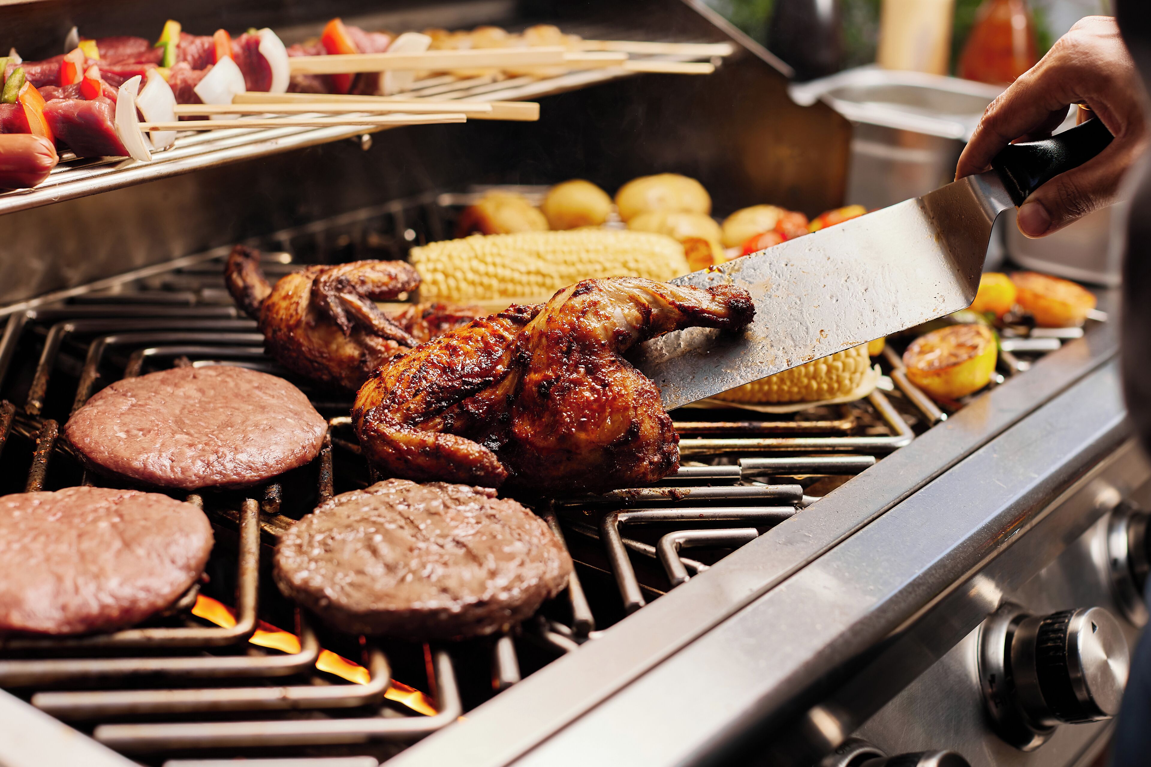 A grill with various meats and vegetables being cooked.