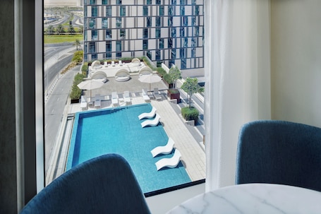 Outdoor pool, pool loungers. Staybridge Suites Dubai Al-Maktoum Airport by IHG