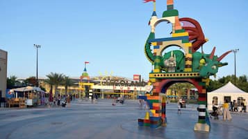A large LEGO-themed sculpture in a public square with a clear sky.