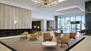 A spacious lobby with a modern chandelier, seating area, and large windows. - Holiday Inn Dubai Al-Maktoum Airport by IHG (Dubai)