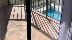 Een balkon met uitzicht op de oceaan en een zwembad.