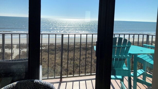 Een balkon met uitzicht op het strand en de oceaan.