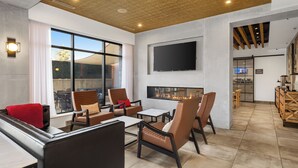 Una sala de estar moderna con chimenea, asientos cómodos y un televisor grande.