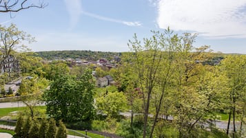 A residential area with a paved walkway, a bridge, and a view of a town in the distance.