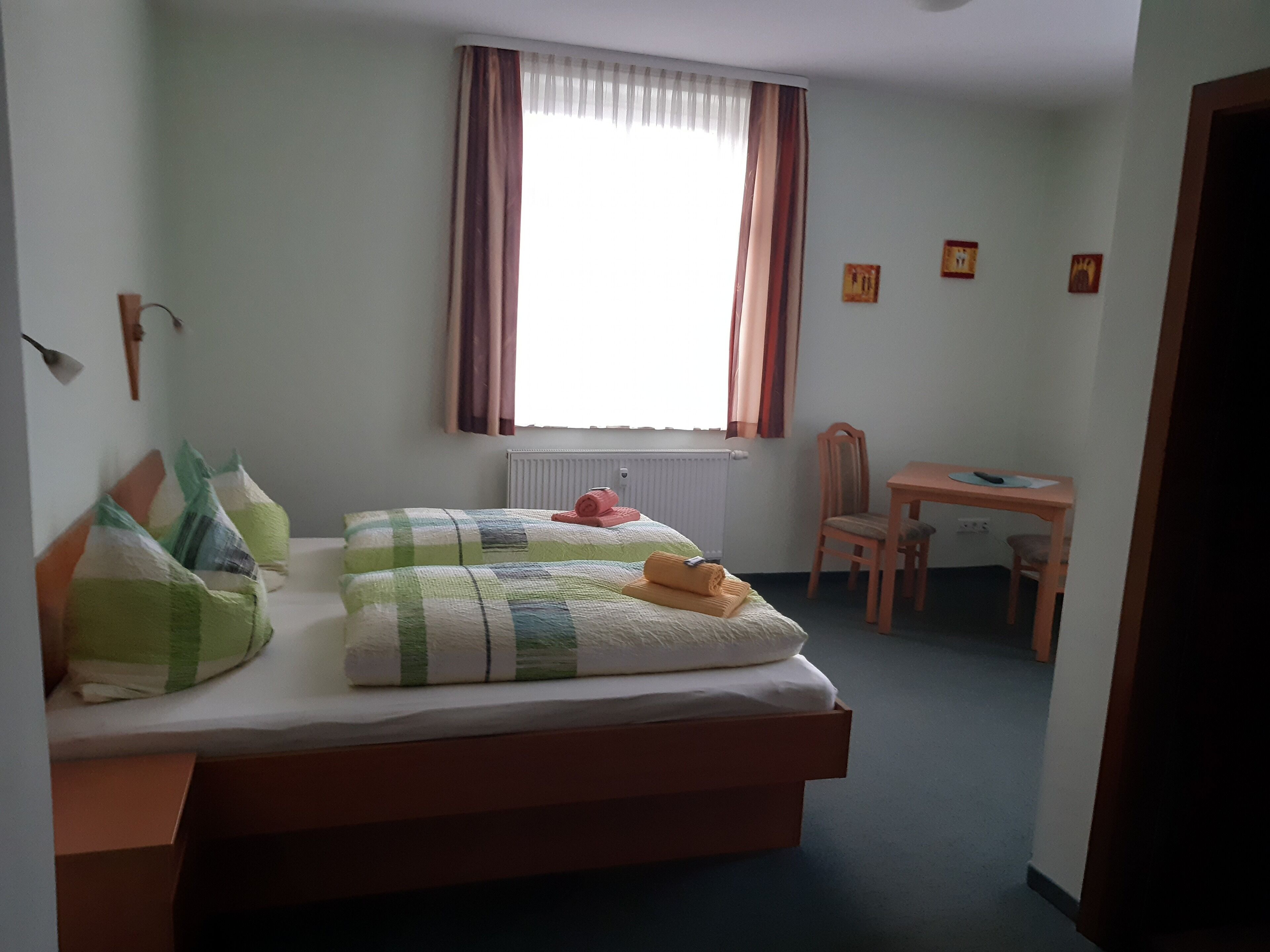 Un dormitorio con cama, escritorio y silla.