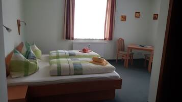 Un dormitorio con cama, escritorio y silla.