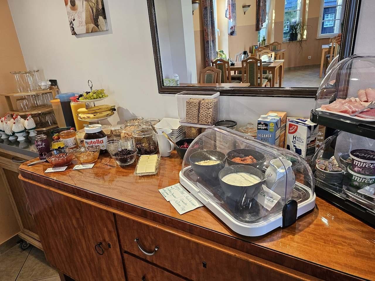 A buffet counter with various food items and condiments.