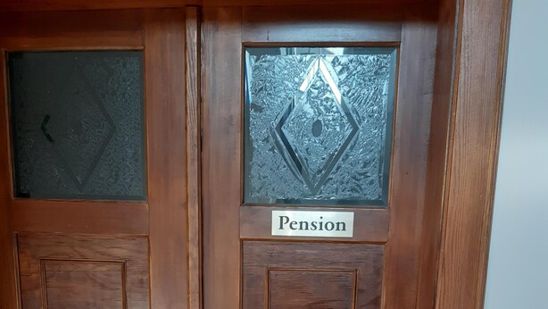 A wooden door with a frosted glass panel and a sign that reads "Pension." - Pension Schöne (Grossrohrsdorf)