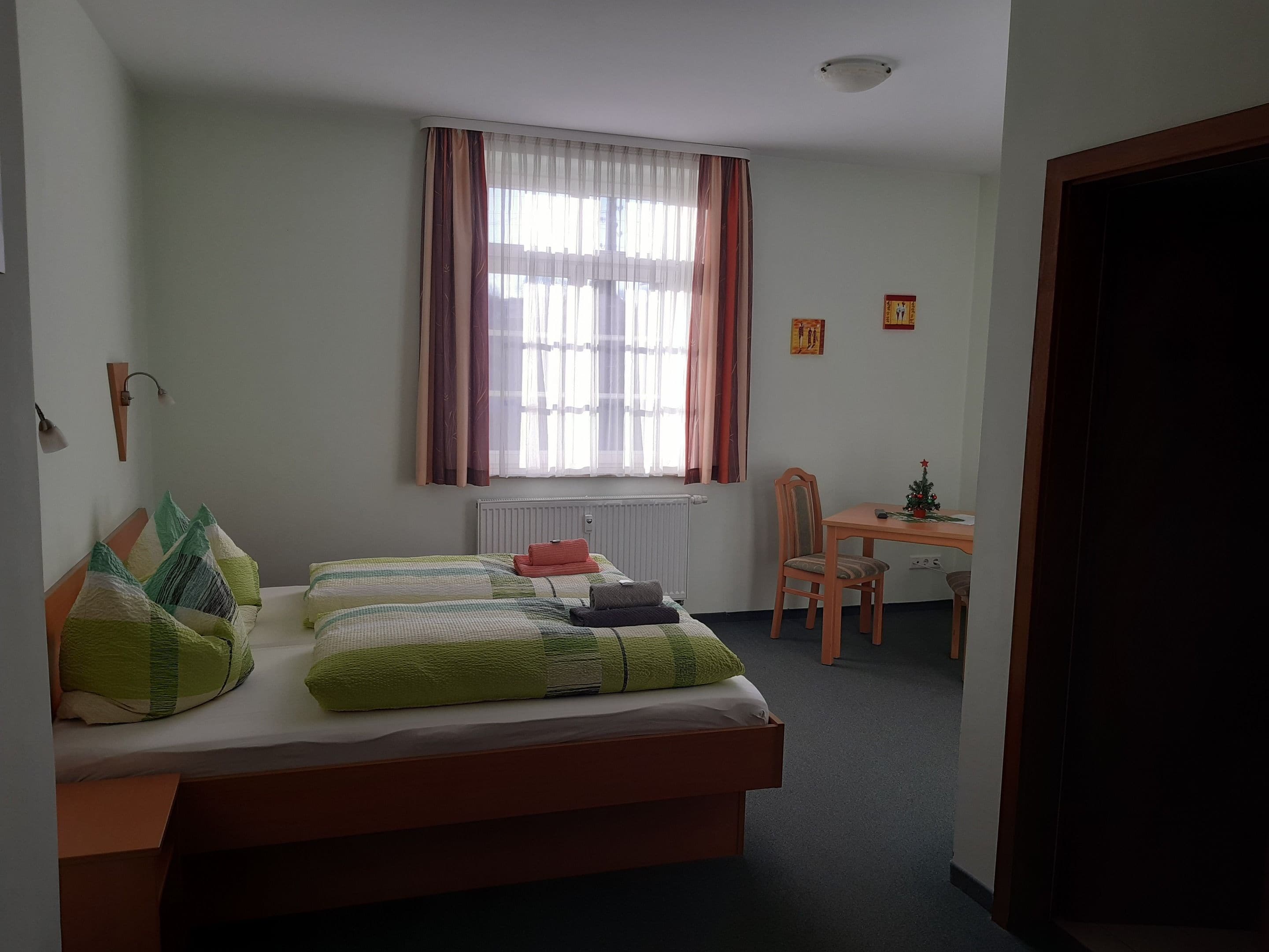 Een slaapkamer met een bed, een bureau en een stoel.