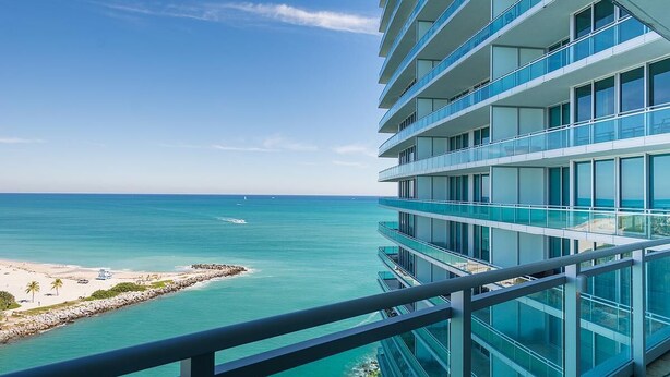 A modern hotel with multiple balconies overlooking a beach and ocean. - Privately managed 2BR+ 2,5Bath  best line oceanfront at the Ritz  Bal Harbour  (Bal Harbour)