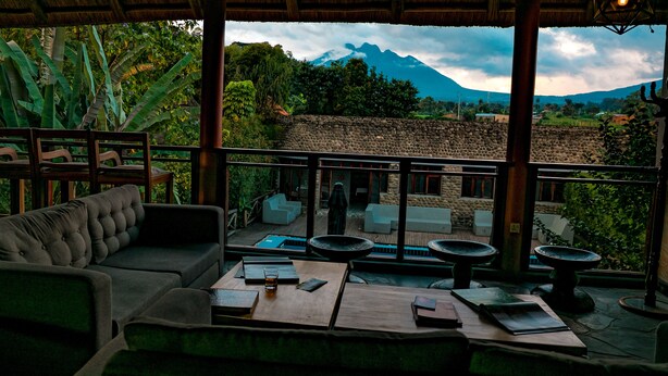 A balcony with a sofa and tables, overlooking a mountainous landscape. - Tiloreza Volcanoes Ecolodge (Cyuve)