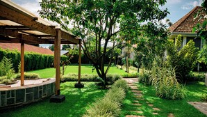 A well-maintained garden with a pergola, stone pathway, and various plants. - Tiloreza Volcanoes Ecolodge (Cyuve)