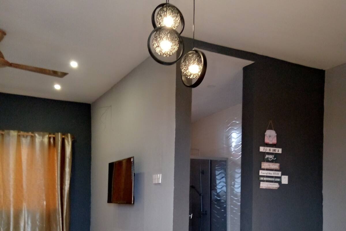 Un comedor moderno con una mesa de madera, sillas de plástico blanco y un candelabro.