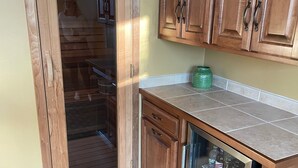 A kitchen with wooden cabinets, a glass-fronted refrigerator, and a tiled backsplash. - Lambeau Field retreat 1.6 Miles from Lambeau 
2k sqft Lower level Luxury Walkout (Green Bay)