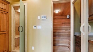 A hallway with wooden paneling, a glass door, and a thermostat on the wall. - Lambeau Field retreat 1.6 Miles from Lambeau 
2k sqft Lower level Luxury Walkout (Green Bay)