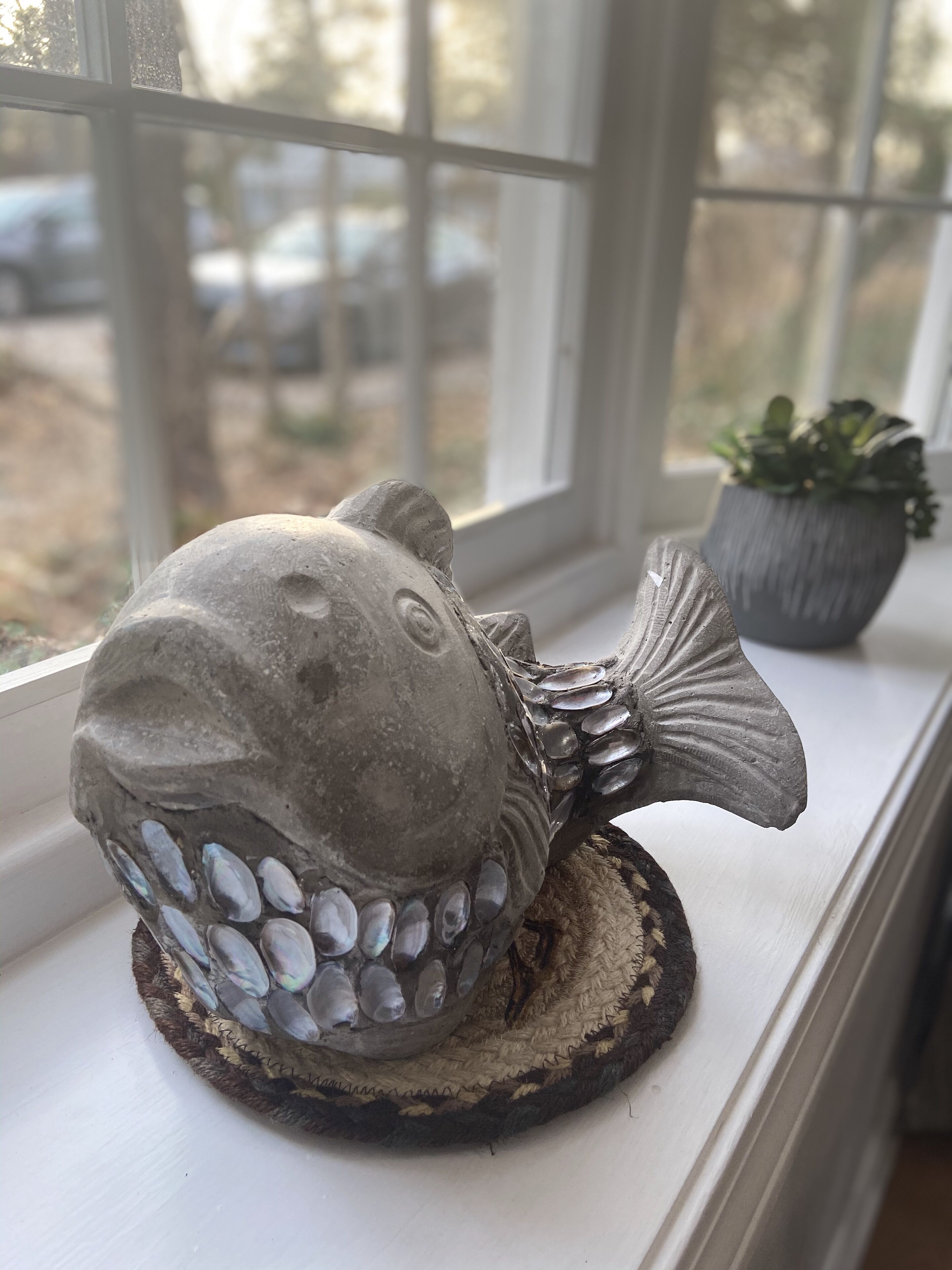 A fish-shaped sculpture on a windowsill.