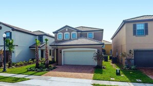 A residential neighborhood with houses featuring tiled roofs and front garages. - Fabulous Single Home w/ Pool at Solterra Resort (Davenport)